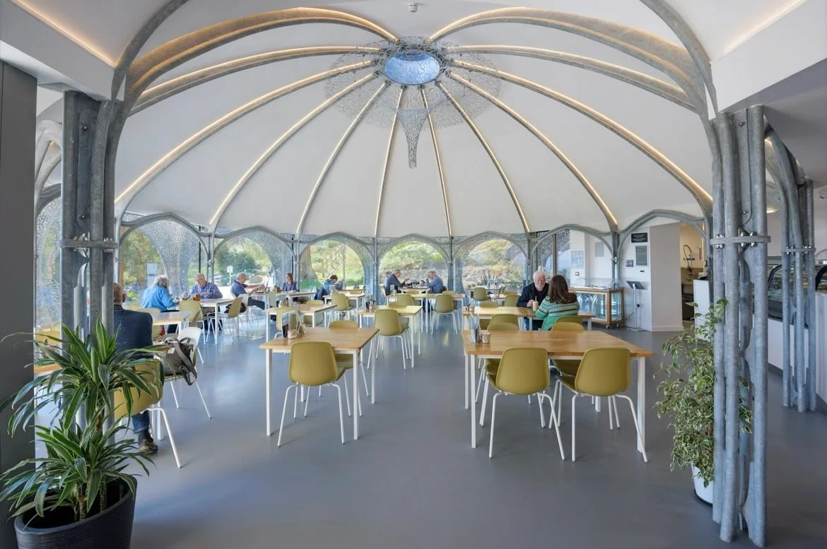 The interior of the caf&eacute; at Plas Glyn-y-Weddw is defined by twelve sculpted galvanised metal beams and columns that rise and converge at a central oculus.   A specialist acoustic and insulating plaster was applied to enhance the sound quality 