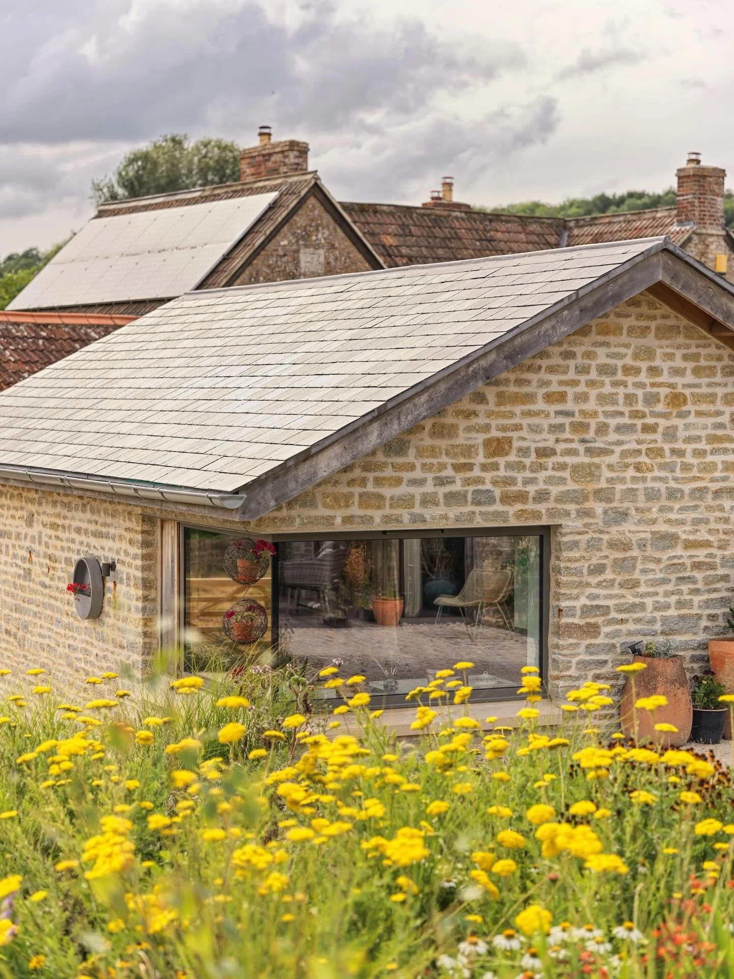 The contemporary detailing of new openings within traditional agricultural forms celebrates the dialogue that exists between past and present. 

The result is an architecture that respects the familiar rhythm of the rural vernacular, yet quietly refl