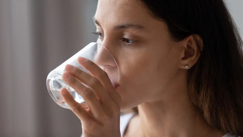 Woman drinking a glass of recently tested water.