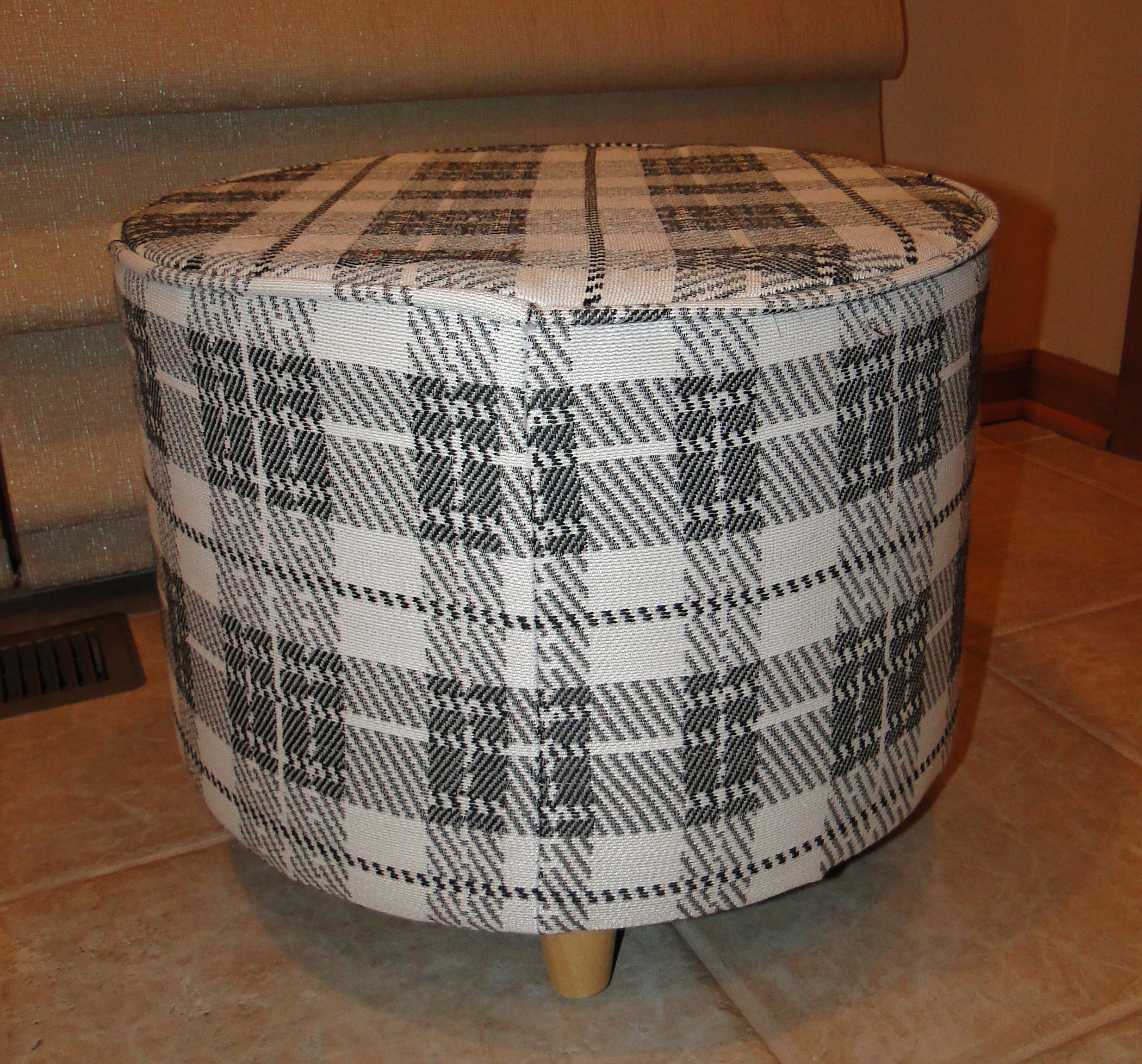 "Before" view of original fabric on ottoman