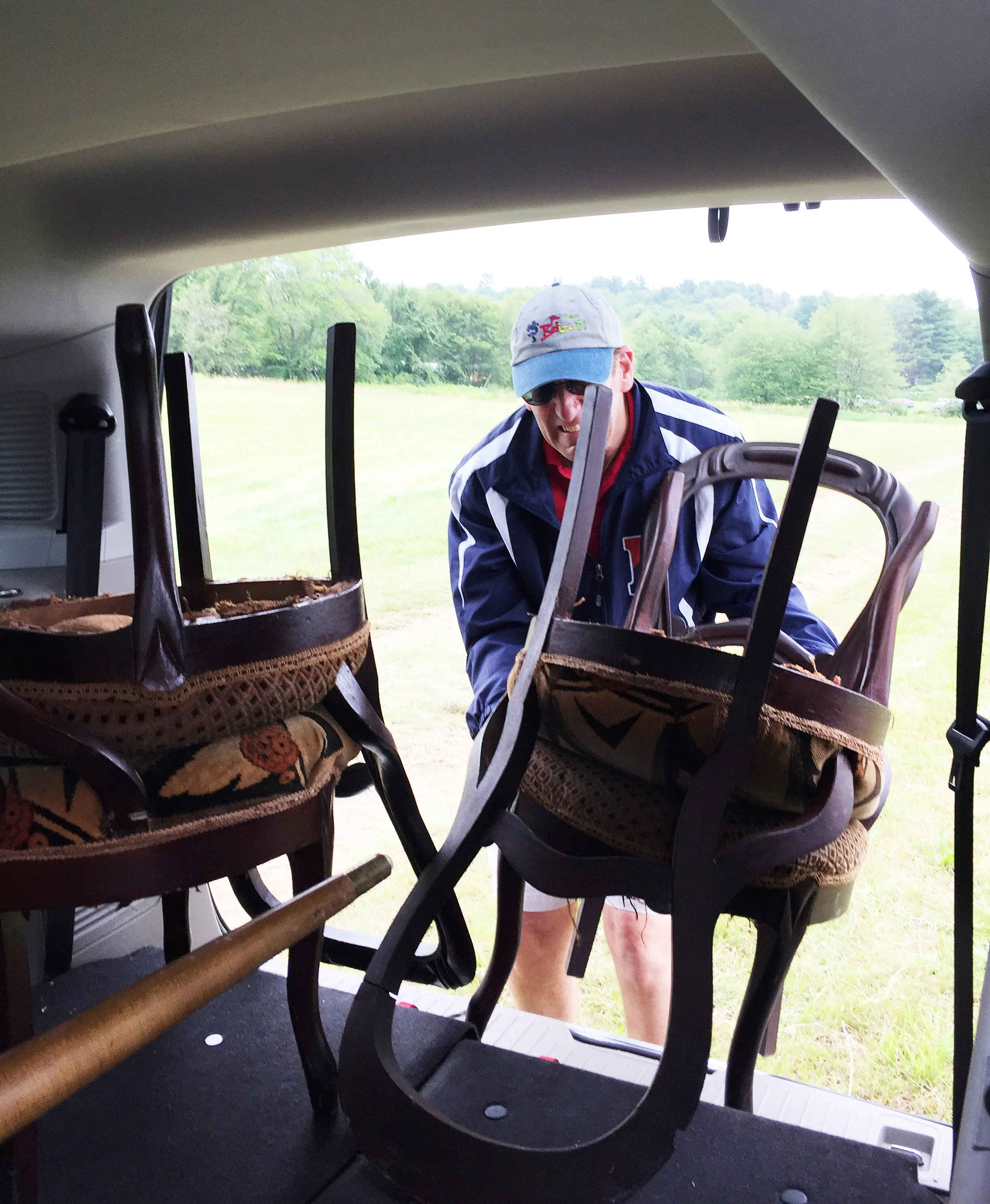 My terrific husband helping to carry chairs many blocks to the van (as the rain was about to start!) — in Brimfield, Massachusetts .