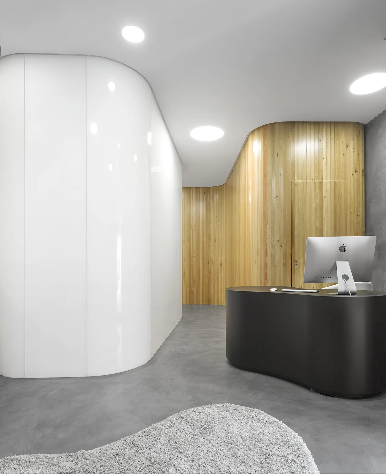  Wood stairs, glossy white walls mixed with textured concrete at DRDERM office by Atelier Central 