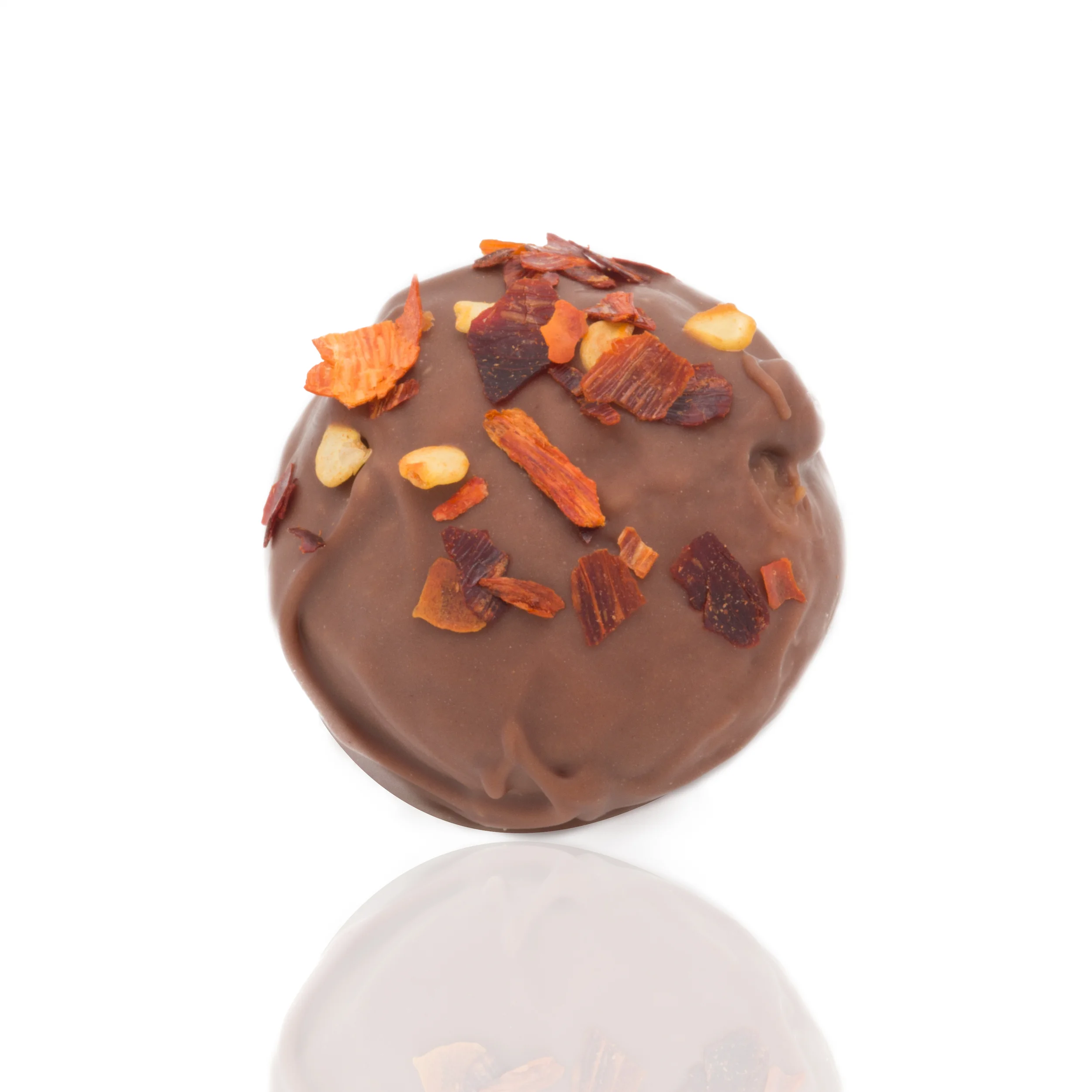 Chocolate truffle decorated with chopped nuts and dried fruit flakes on a white background.