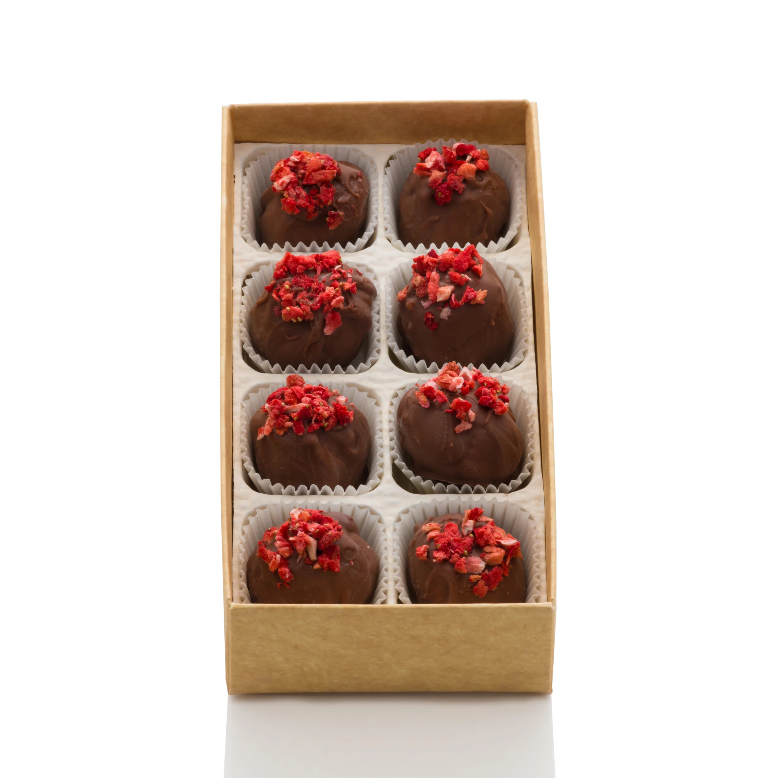 A box of nine chocolate truffles topped with red crushed freeze-dried strawberries, arranged in three rows and three columns in a tan cardboard box.