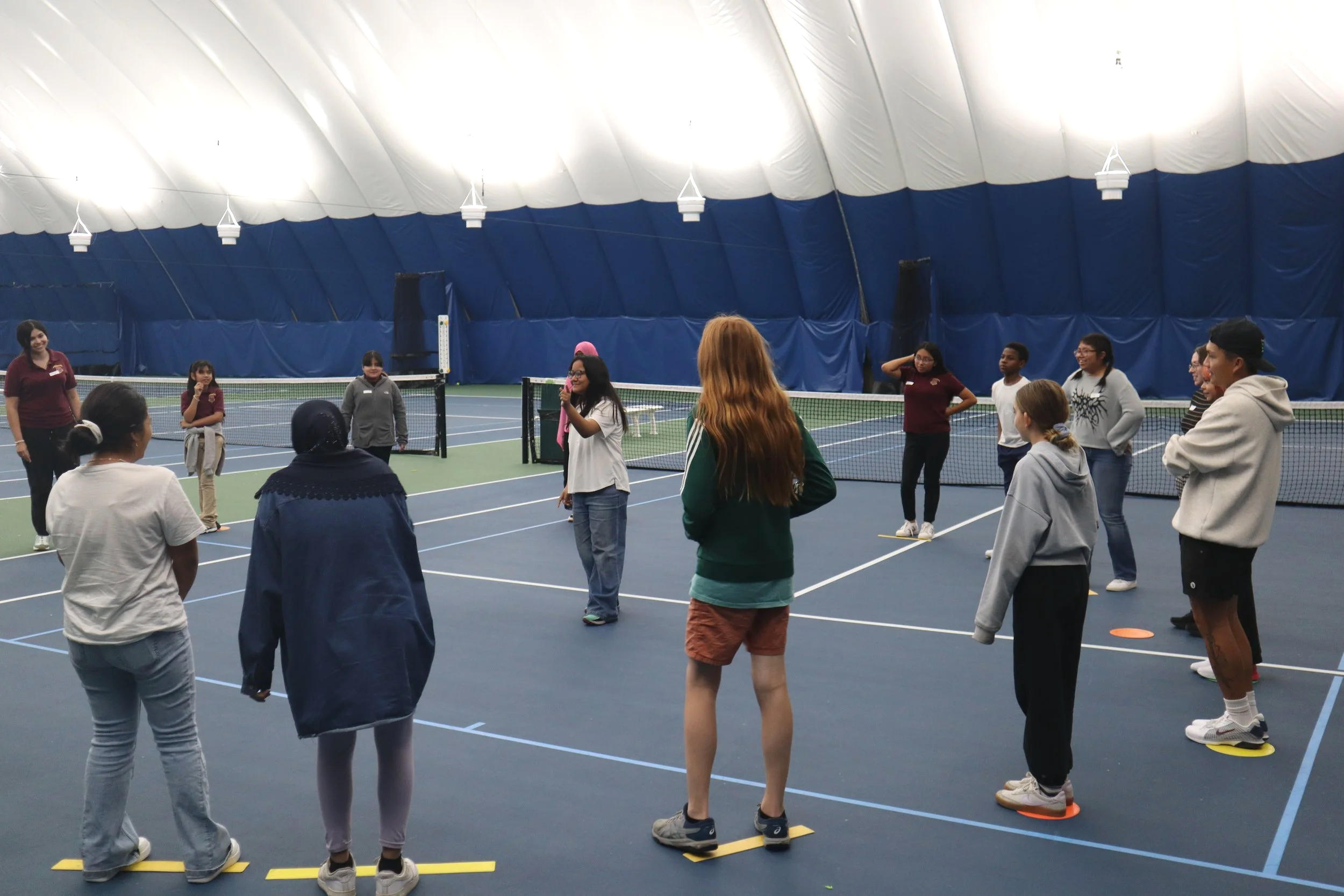Group of after school students standing in circle on court