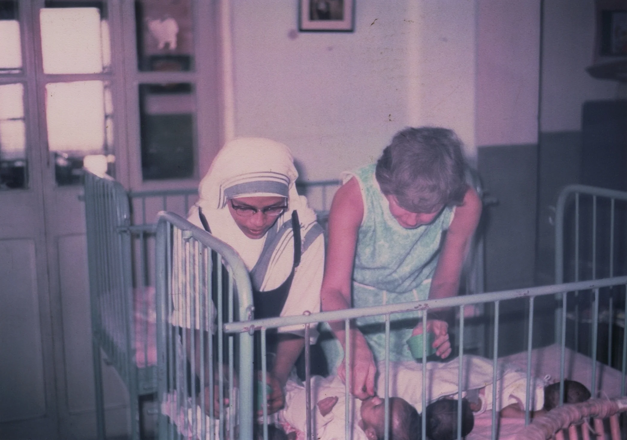 1968 One of Mother Teresa's Sisters and Eleanor McPhillips tend to orphans at the Missionaries of Charity in Kolkata, India.