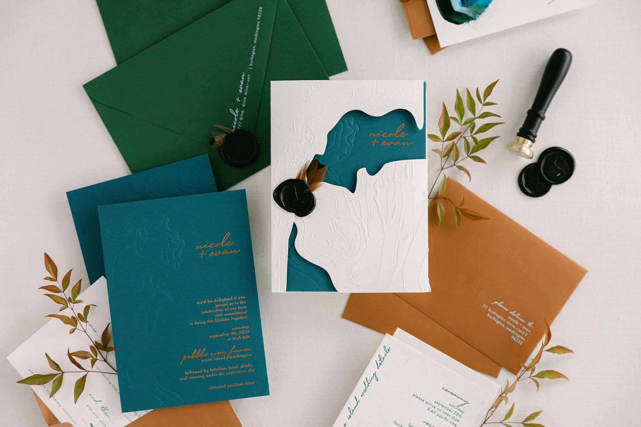 Close-up of teal wedding invitation with copper foil