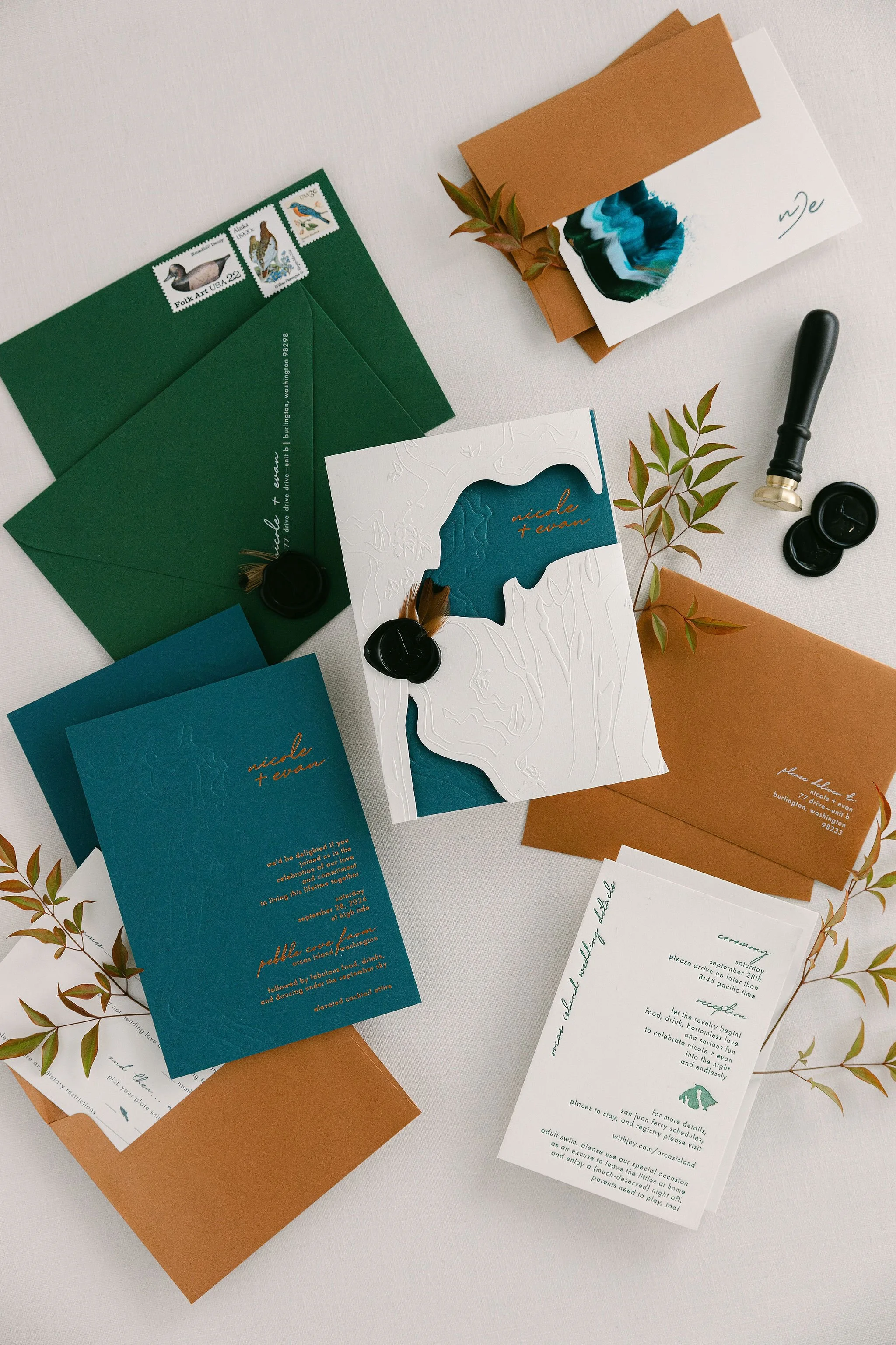 Flat lay of Nicole + Evan’s teal and copper invitation suite