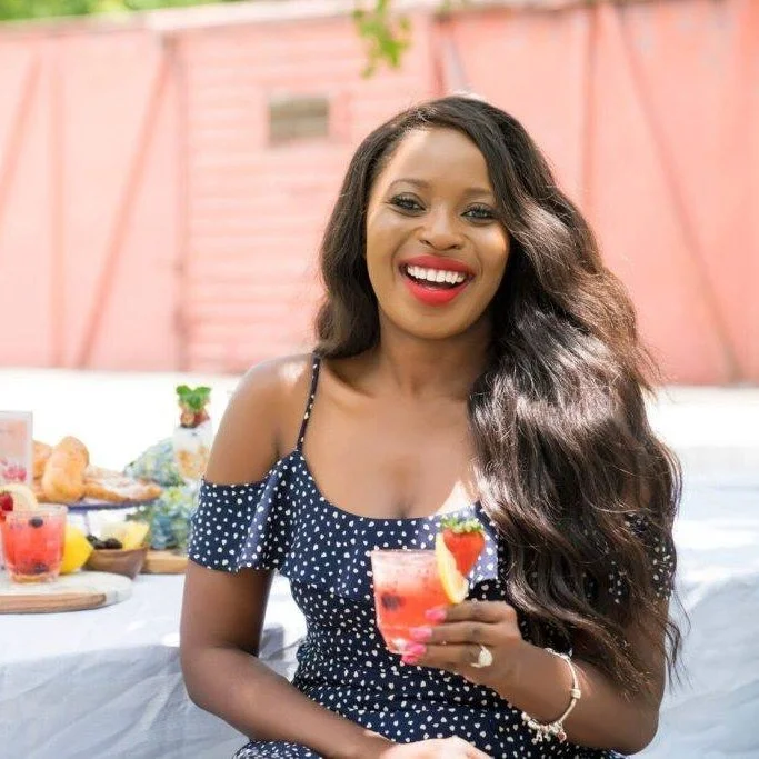 Headshot of Erica Key smiling and holding a cocktail.