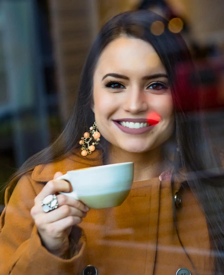 Headshot of Sarah Puett smiling and holding a coffee mug.