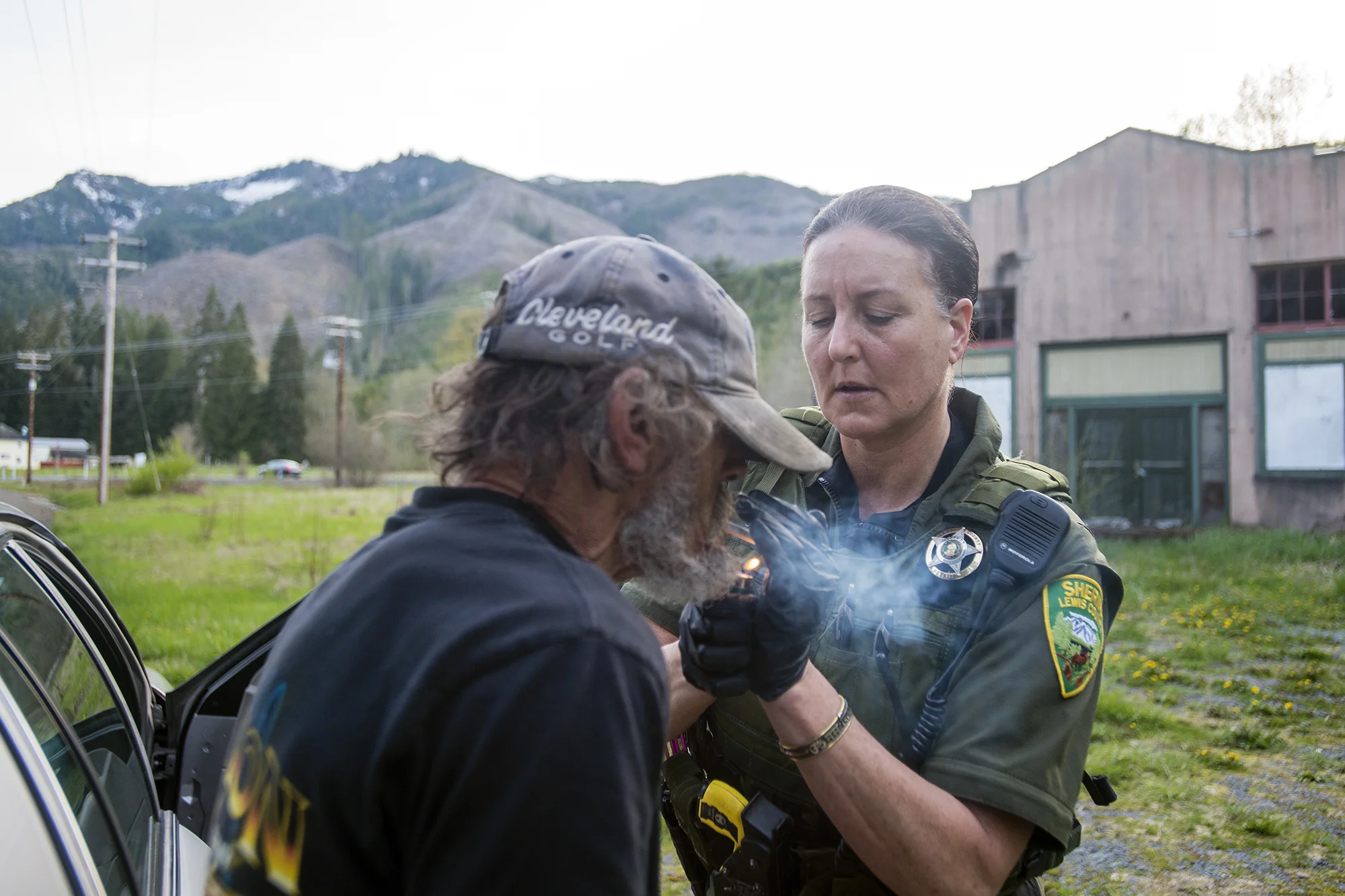  After repositioning Richard Jacoby's handcuffs, Lewis County Sheriff's Deputy Sue Shannon makes good on a promise to give Jacoby a smoke before they make the 30-minute drive back to Mossyrock where he would be picked up by a pair of deputies and bro