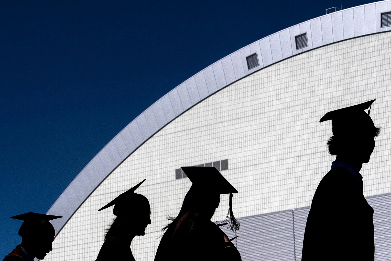  University of Idaho graduates are silhouetted as they walk toward the entrance of the Kibbie Dome for the school's Spring Commencement Ceremony on Saturday, May 12, 2018 in Moscow, Idaho. 