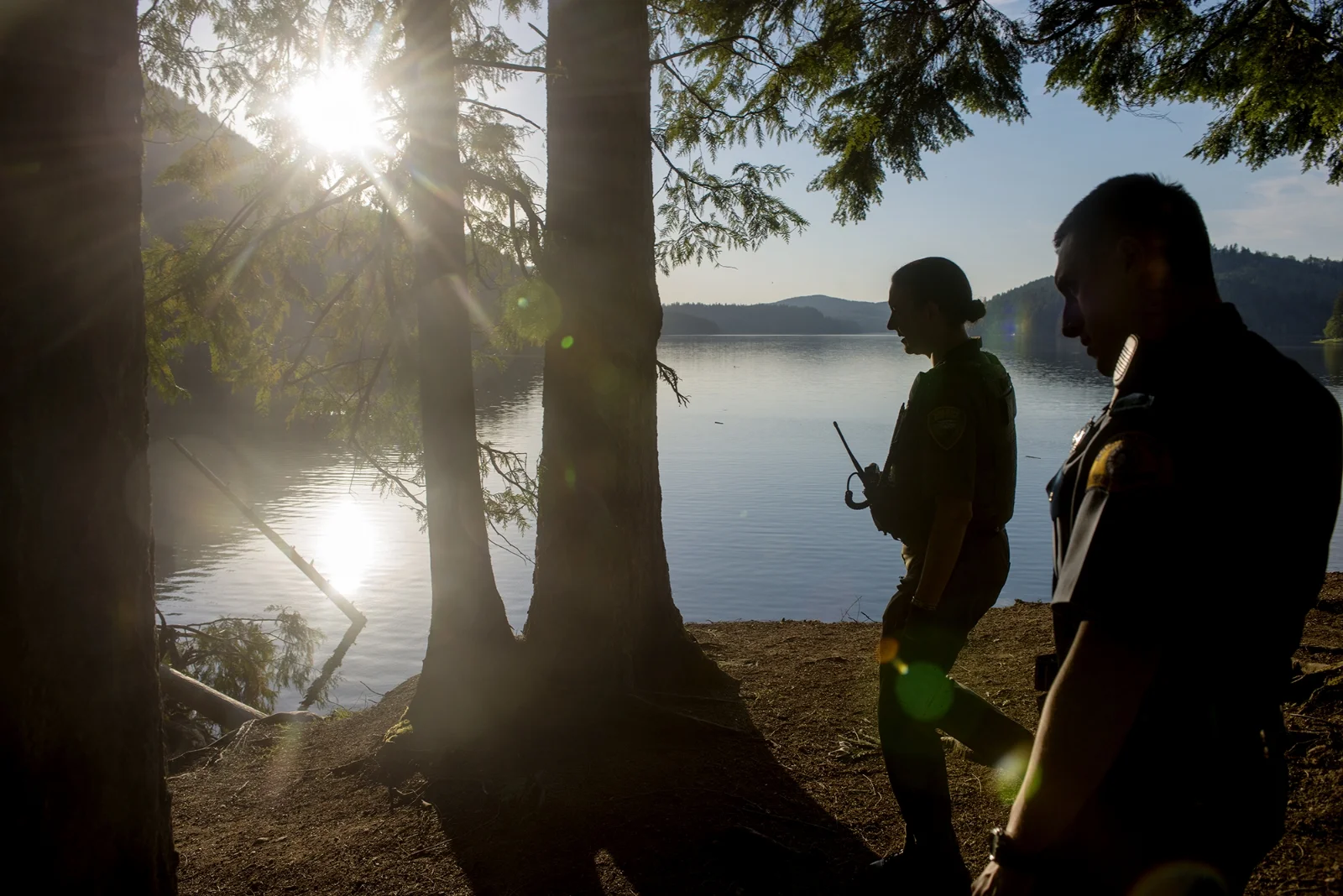  After making contact with a group of youths supposedly partying on the cliffs overlooking Alder Lake, Lewis County Sheriff's Deputy Sue Shannon, left, and Washington State Patrol Trooper Michael Farkas make the quarter-mile hike back to their respec