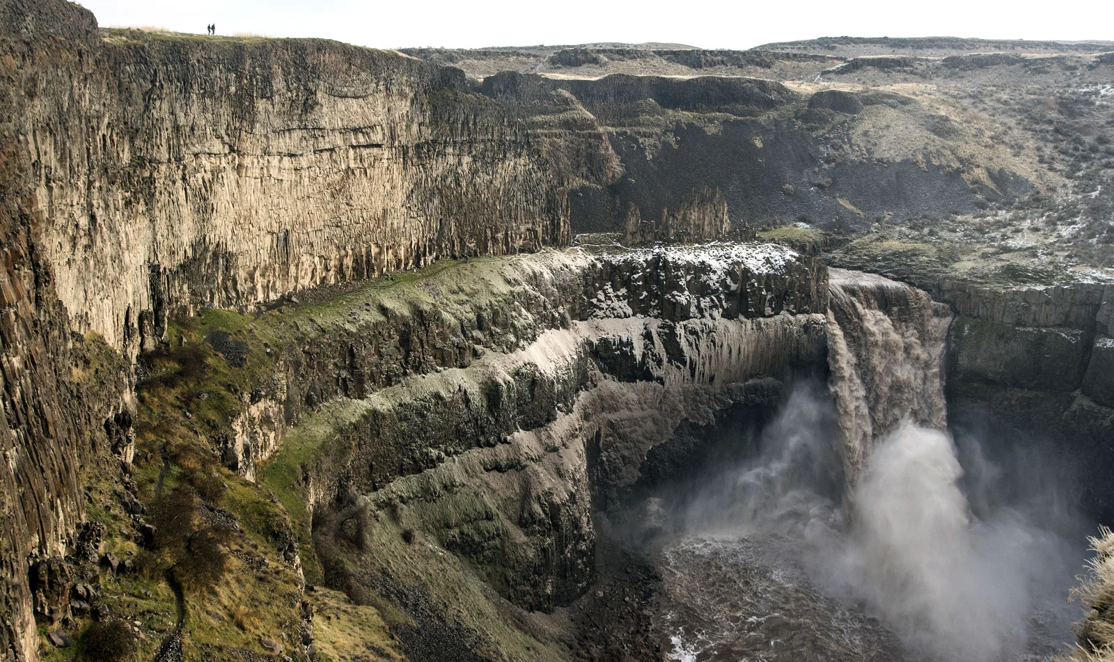 Colby Erb and Callie Lawrence, both from East Wenatchee, stand on a cliffside overlooking a raging Palouse Falls on Sunday, Dec. 31, 2017, at Palouse Falls State Park. In the past few days, record-setting rainfall and warm weather on the Palouse melted much of the current snowpack which eventually made its way the downriver. According to the U.S. Geological Survey's National Water Information System, as of Sunday afternoon the Palouse River was cascading over the falls at 5,870-cubic-feet-per-second. However, on Saturday, water was traveling over the falls at over 9,000-cubic-feet-per-second, according to the USGS measurements.