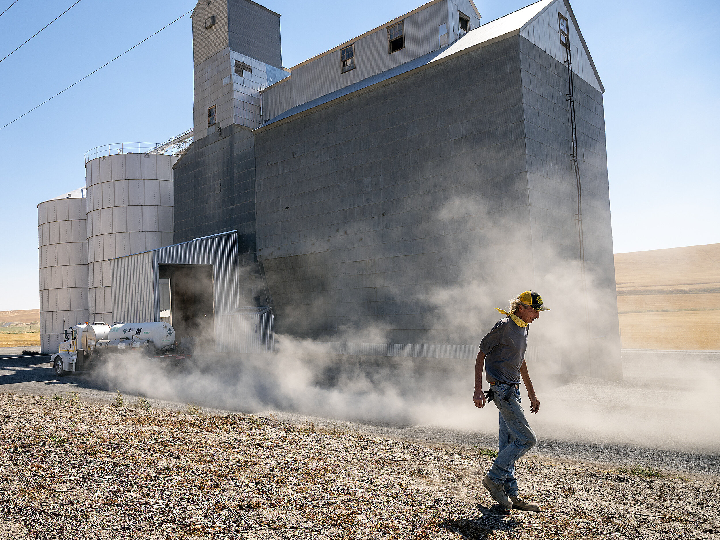  Dust kicks up into the air as a truck speeds by along Leon Road as Tony Egland, the warehouseman at the Leon Grain Elevator walks around the building on Wednesday, Sept. 2. 