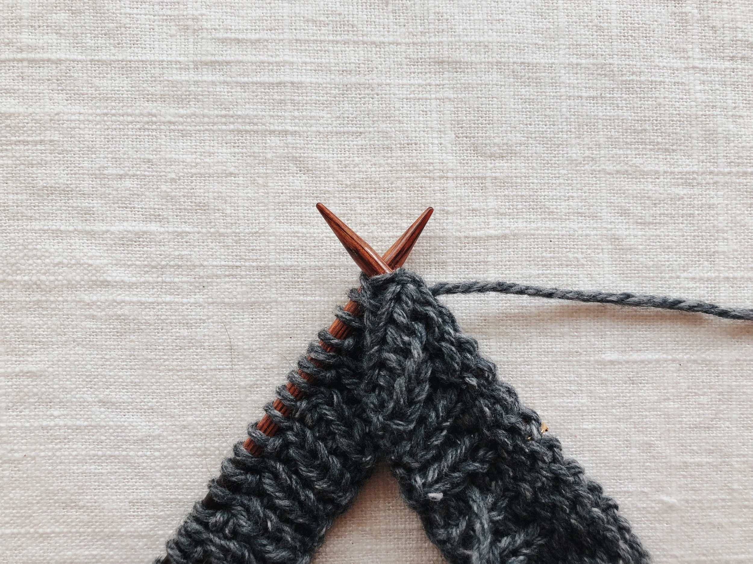 Purl the lifted stitch with the stitch on the left needle together through the back.