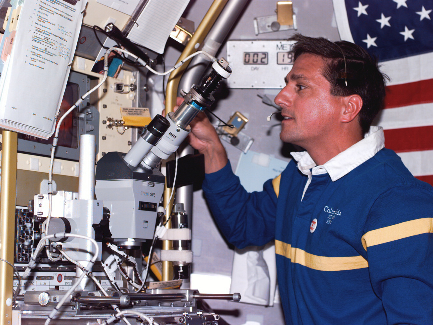  Using microscope at the microgravity glove box facility in Spacelab. 