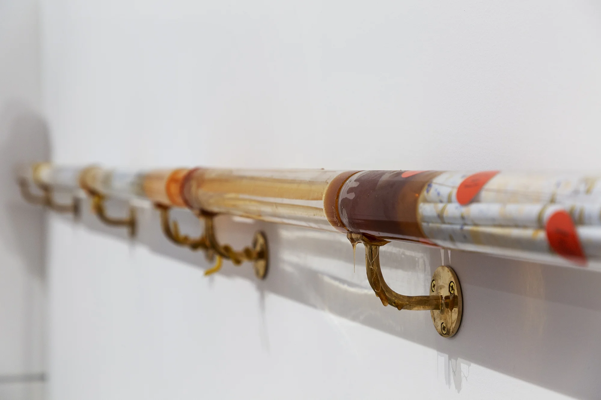 Mo Kong, “Dream” Guid , 2018. Acrylic tubes, handrail brackets, hand blown glass, rubber, ceramic , honey, shredded government documents, pollen, beeswax, handmade lens, drawings, 3 x 250 inches.