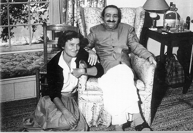 AVATAR MEHER BABA (seated) when He visited Meher Mount on August 2, 1956. This photo is taken with caretaker Agnes Baron beside Him. They are in the guesthouse where Meher Baba met with His followers that day. This building was completely destroyed in the 1985 New Life Fire. (Archive photo.)