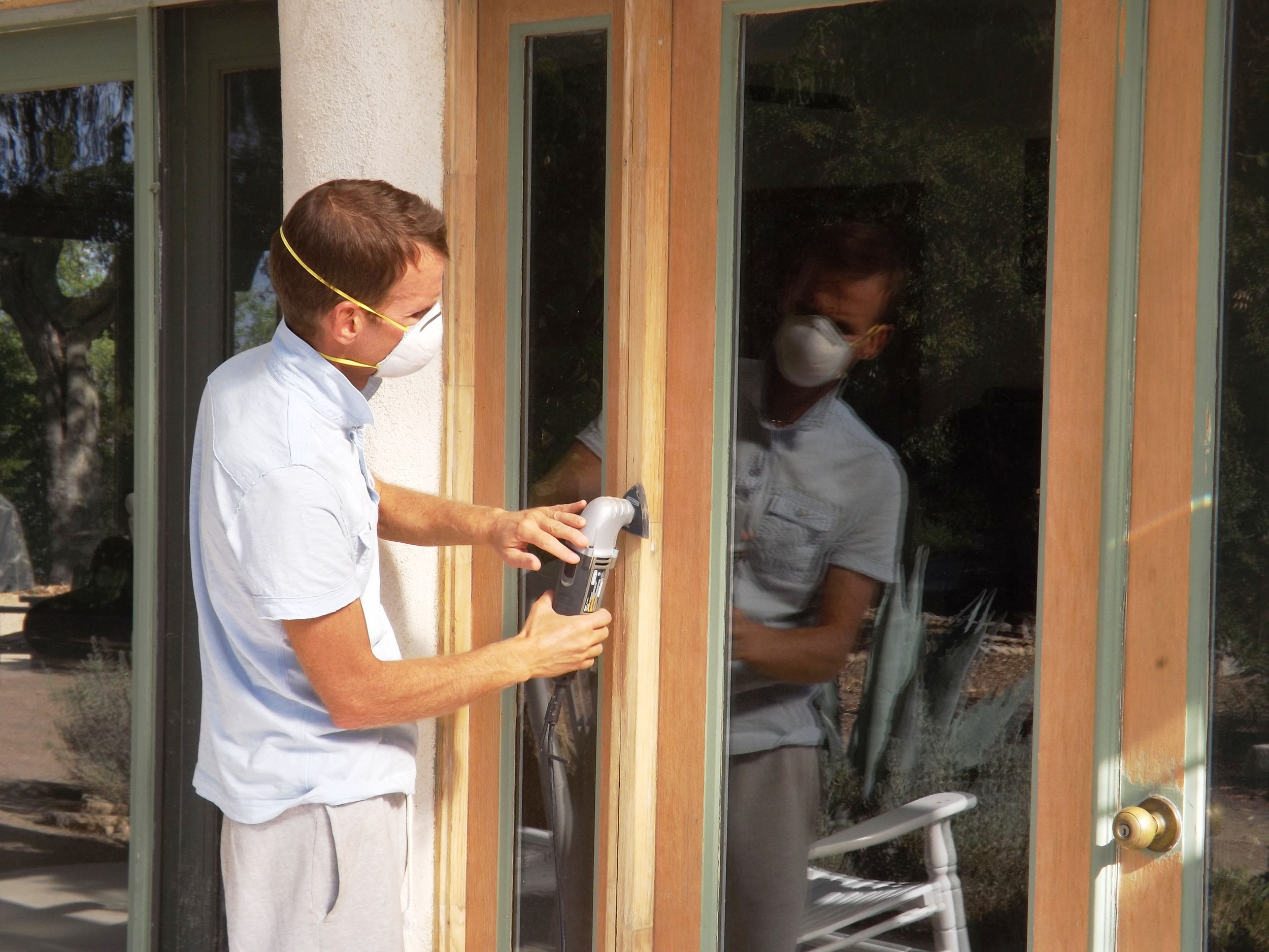 STRIPPING AND SANDING the window and door frames was part of upgrading the building. Manager/Caretaker Leslie Bridger is busy at work. (Rebecca Bridger photo, 2010.)