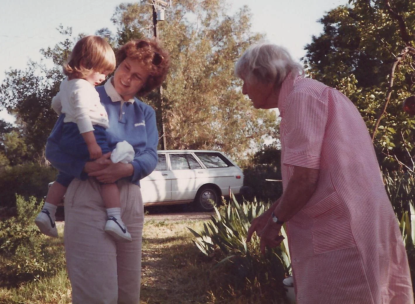 THE WHITE TOYOTA station wagon that Agnes Baron (right) got for herself is in the background. Visiting Agnes are (left) Margaret Magnus and her daughter Stephanie Ervin. (Sam Ervin photo, 1985.)