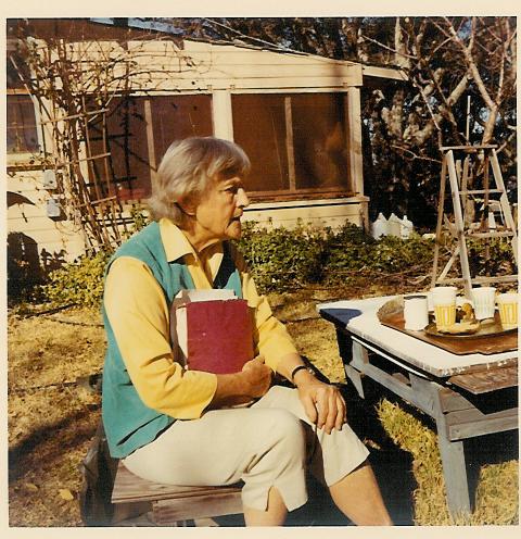 AGNES BARON holding a copy of The Unstruck Music of Meher Baba while visiting with guests at Meher Mount. (Sam Ervin photo, 1979.)