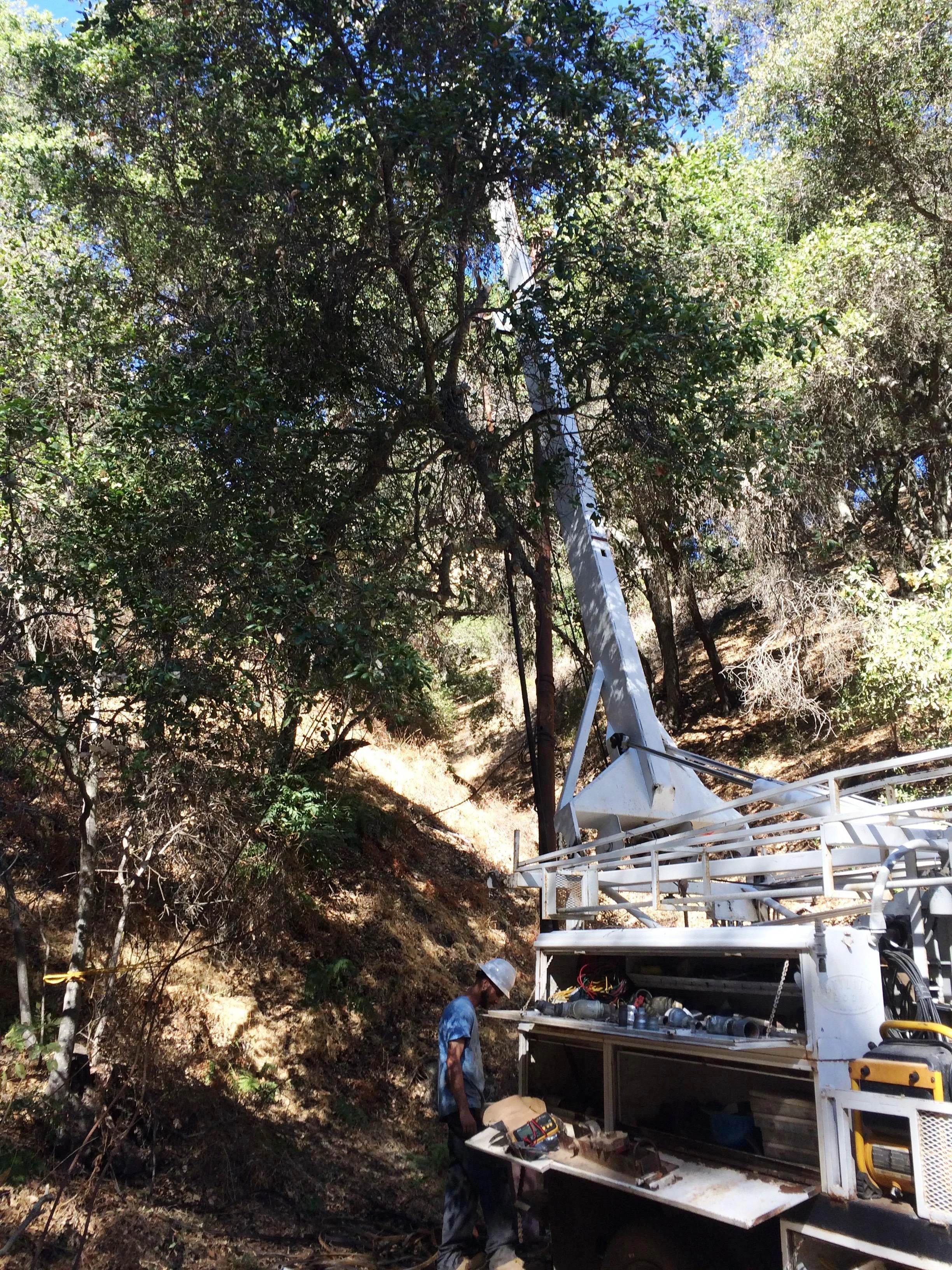 HANSEN WELL-DO SERVICE assessing the well and pump situation at the well head located in a ravine at Meher Mount. (Photo: Buzz Glasky, 2016) 