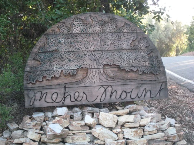HAND-CARVED, WOOD SIGN created by former Board member Jim Auster at the entryway to Meher Mount for many, many years. (Photo: Sam Ervin, 2015)