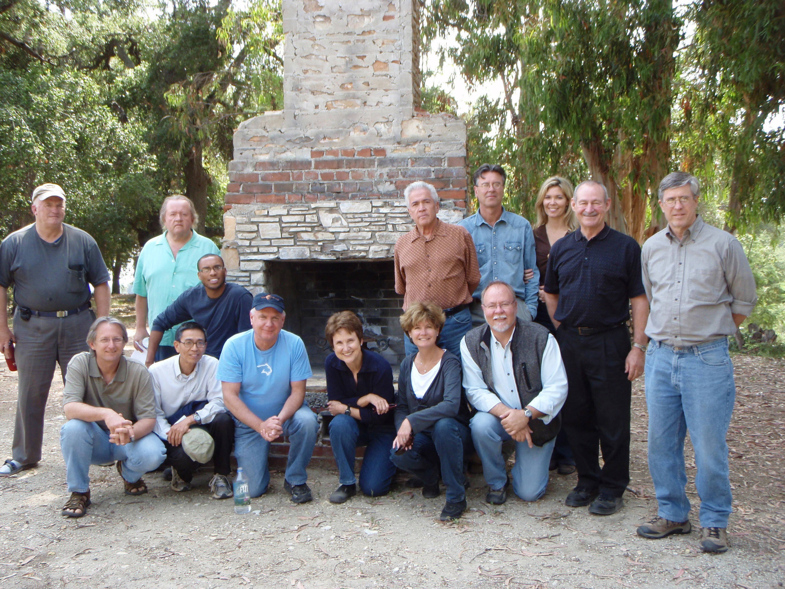 A PLANNING GROUP in front of Baba's Chimney in 2008. (Left to right, standing): Marko Swearingen, Ken Pellman, Michael Markley, Ray Johnston, Elizabeth Arnold, Sam Ervin, and Bing Heckman. (Left to right, kneeling): David McNeely, Kanji Miyao, Ron Holsey, Jim Whitson, Margaret Magnus, Nancy Pinckert, and Byron Pinckert.
