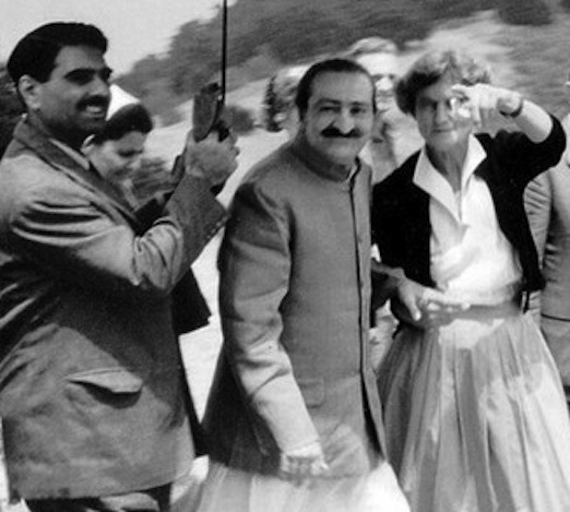 AVATAR MEHER BABA at Meher Mount on August 2, 1956. Close disciple Eruch Jessawalla is holding the umbrella and Meher Mount caretaker Agnes Baron is pointing out something to Meher Baba. 