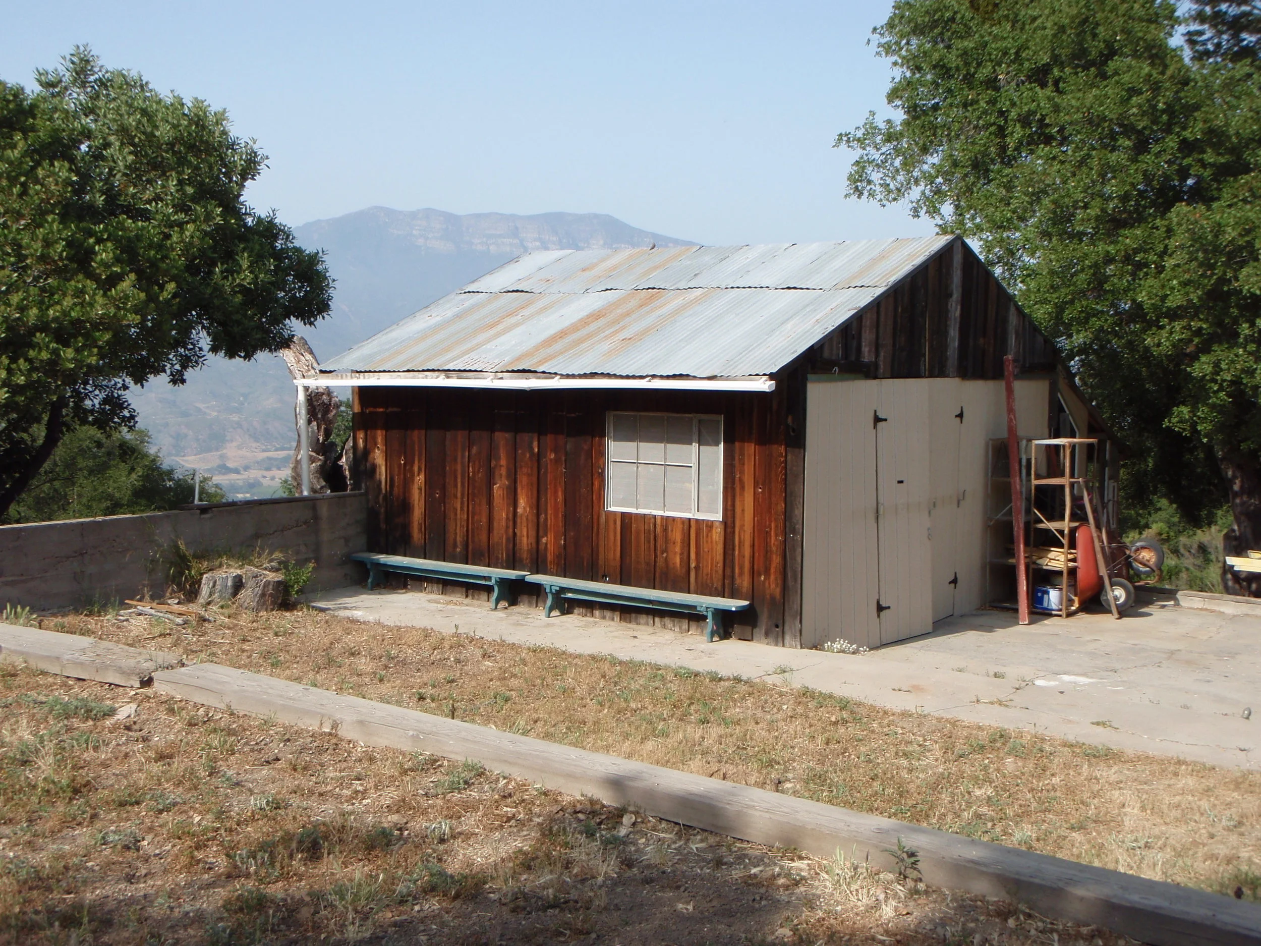 THE "TEMPORARY" WORKSHOP built in 1985 with found materials. There were subsequent repairs and a door replacement in later years. (David McNeely photo, 2008.)