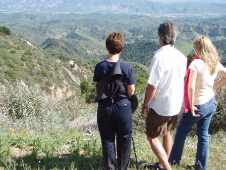 RAY JOHNSTON (center) points out the location of the corner post to Margaret Magnus (left) and Elizabeth Arnold (right) which Meher Baba had asked Agnes Baron about. (Sam Ervin photo.)