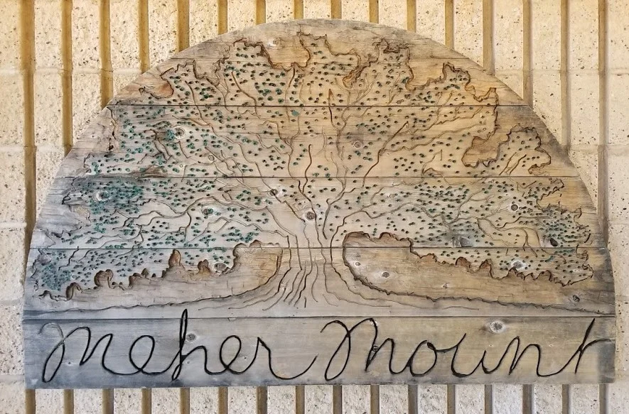 THE NEW HOME for the cedar gateway sign created by Jim Auster in 2001. It's on the outside of the Workshop facing the Topa Topa Patio. (Photo: Margaret Magnus, 2017)