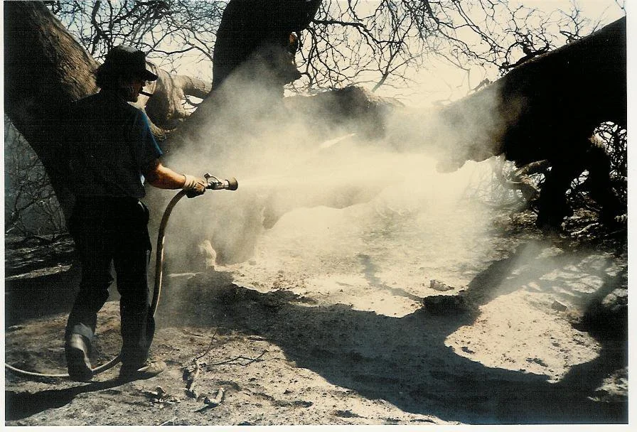 FIREMEN WERE STILL putting out the fire at Baba's Tree on October 19, 1985, five days after the New Life Fire burned all the structures and vehicles at Meher Mount. (Photo: Sam Ervin, October 19, 1985)