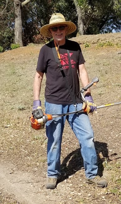 JIM WHEDON with a gas-powered weed wacker to reach difficult places. (Photo: Margaret Magnus, May 19, 2018)