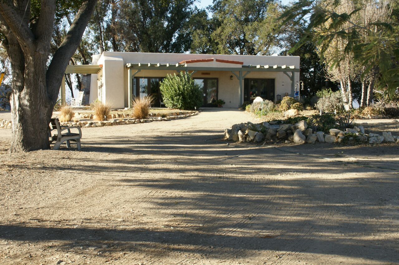 VISITOR CENTER/CARETAKER QUARTERS days after the 2017 Thomas Fire hit Meher Mount. The burned corner beams of the trellis are barely visible. It's on the left-hand corner of the trellis facing forward. (Photo: Byron Pinckert, December 21, 2017)