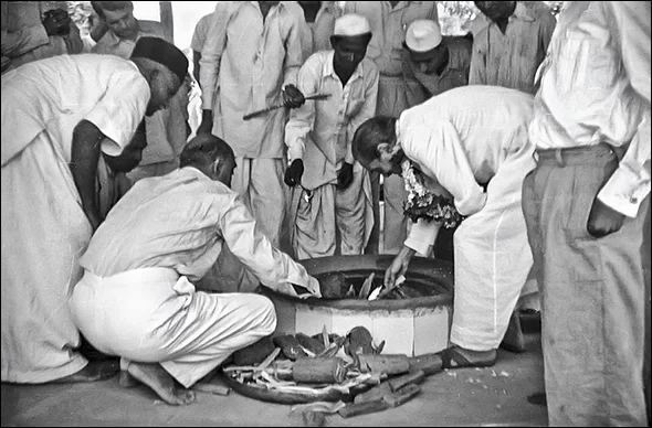 AVATAR MEHER BABA lights the dhuni in Meherabad, India, home of His Tomb Shrine in the 1950s. (Photo: MN Publications)