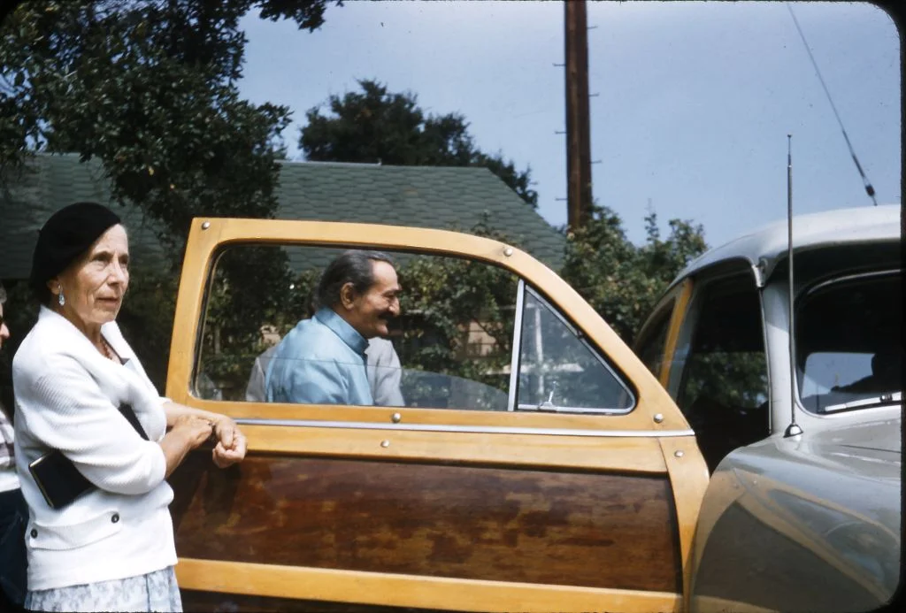 AVATAR MEHER BABA entering the ‘Woody’ driven by Agnes Baron as He prepares to leave Meher Mount for the ride back to Hollywood on August 2, 1956. Pictured with Him is Kitty Davy, a close Western disciple, and one of the pillars of the Meher Spiritual Center in Myrtle Beach, SC. (Photo: Darwin Shaw, ©Meher Nazar Publications)