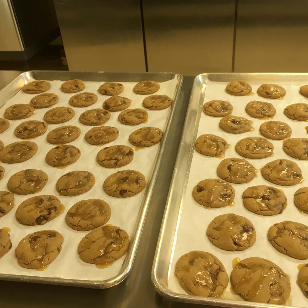 A freshly-baked batch of our new flavor: HONEY SALTED CARAMEL DARK CHOCOLATE CHIP. Irresistibly sweet &amp; salty! We baked plenty and are stocked up for the weekend - if you're in the neighborhood why not stop by and pick up a dozen (or two)? You ca