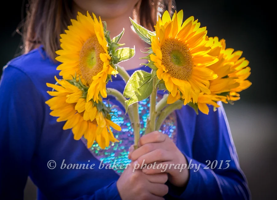 And here's a portrait of the sunny sunflowers themselves. I love how they look against the girl's cobalt blue shirt (and I love how the sparkly heart shows just behind the stems!).
