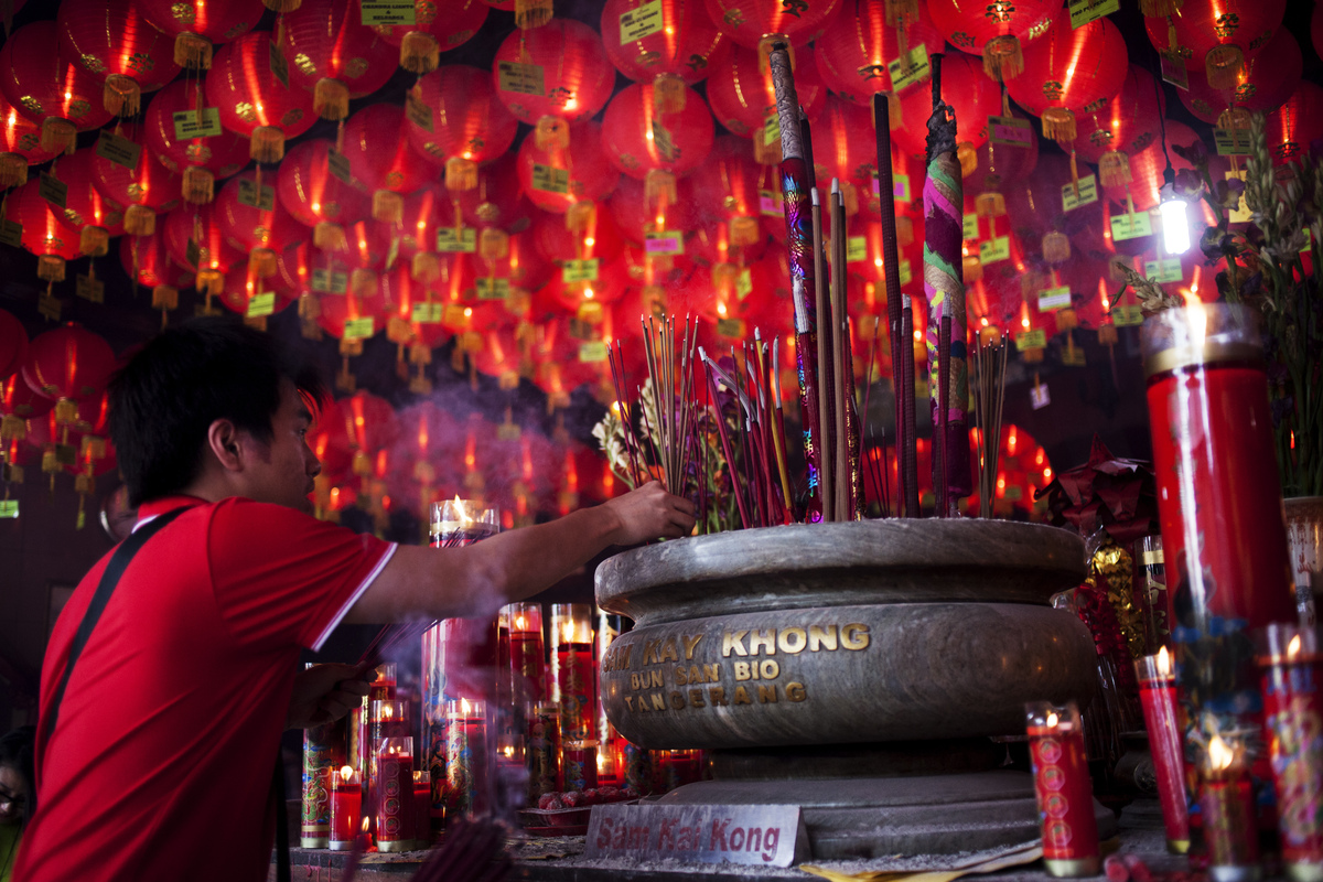 TANGERANG, INDONESIA - JANUARY 31: A man holds incense sticks as she attends prayers during Chinese New Year celebrations for the Year of The Horse at Bun San Bio Temple on January 31, 2014 in Tangerang, Indonesia. Indonesian chinese today to celebrate the Chinese New Year and welcome the Year of the Horse, with new year's day falling on January 31st. Chinese new Year is the most important festival in the Chinese calendar and is widely celebrated across Asia. (Photo by Oscar Siagian/Getty Images)