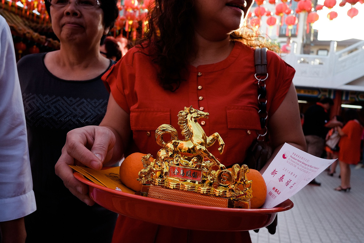 KUALA LUMPUR, MALAYSIA - JANUARY 31: A Chinese ethnic holds a golden horse statue as part of her offering in Tien Hou Temple as Malaysian celebrate Chinese New Year on January 31, 2014 in Kuala Lumpur, Malaysia. Chinese New Year is traditionally celebrated from the last day on the last month of the Chinese lunisolar calendar to the Lantern Festival on the 15th day of the first month. (Photo by Rahman Roslan/Getty Images)