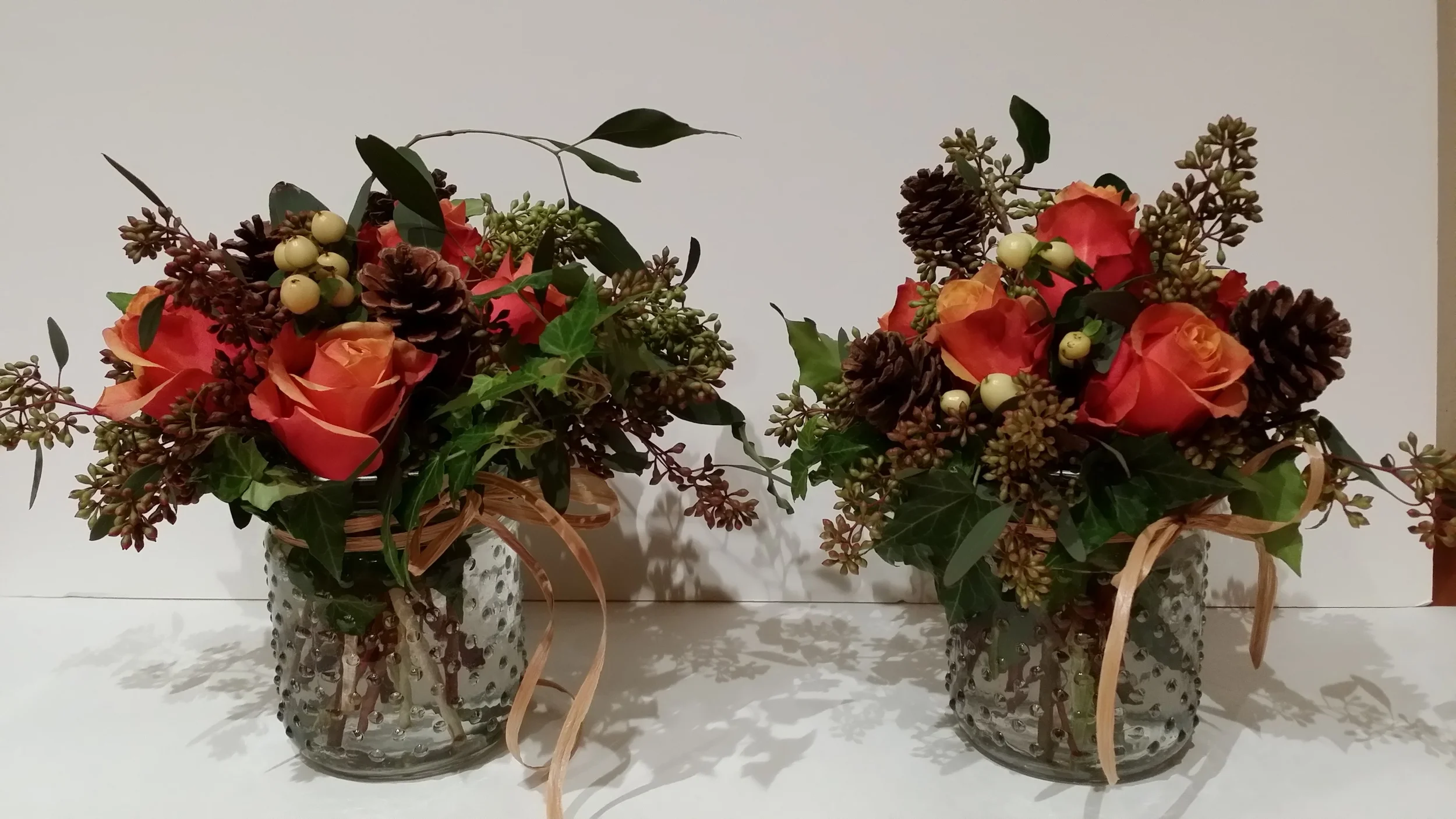 4" nobbed jar with Cherry Brandy Roses, White Hipericum berries, seeded eucalyptus, and ivy. Price starting at $25.00