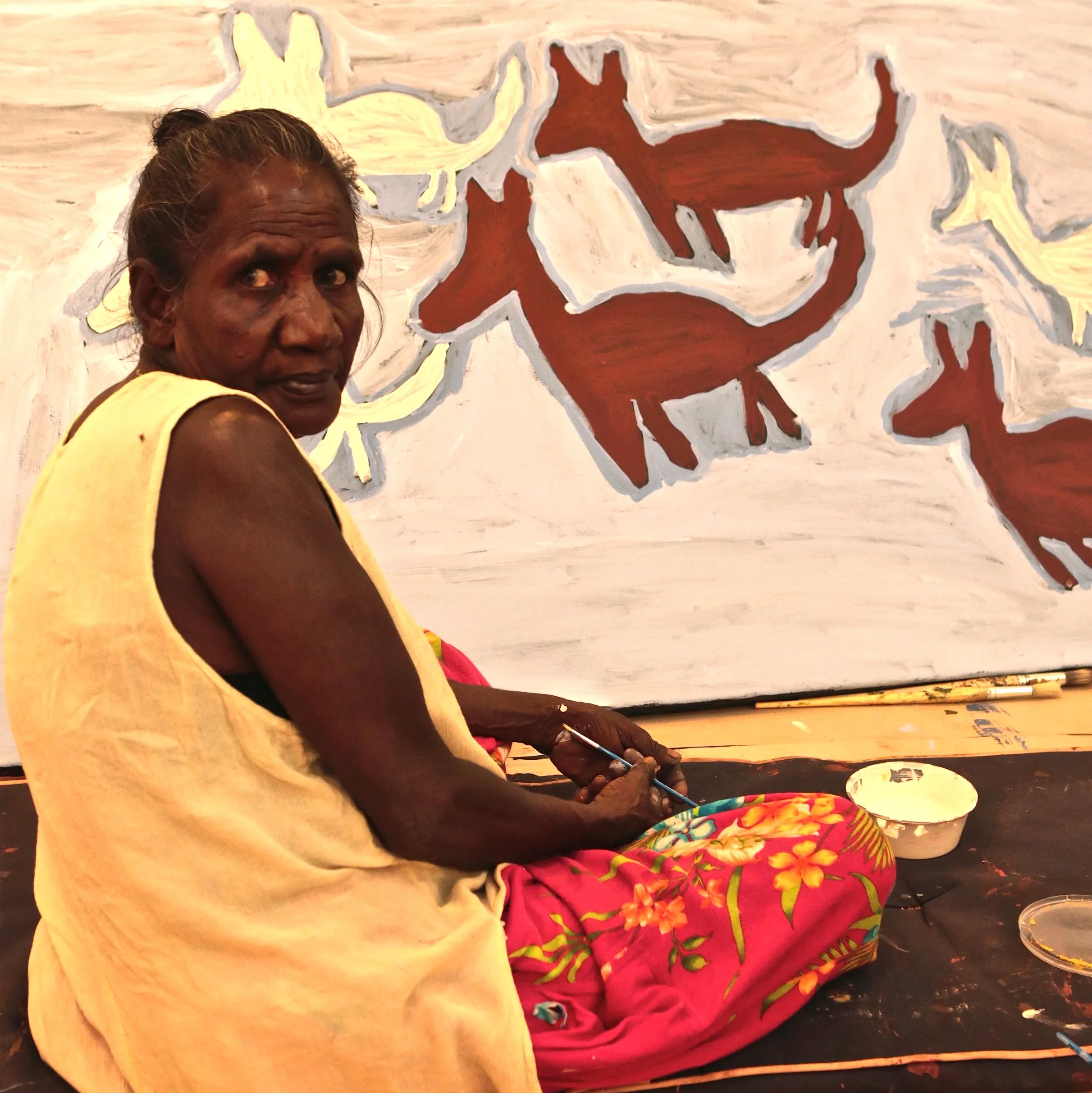 Artist Ruth Lulwarriwuy working on one of her large Dhuwa and Yirritja dog paintings.