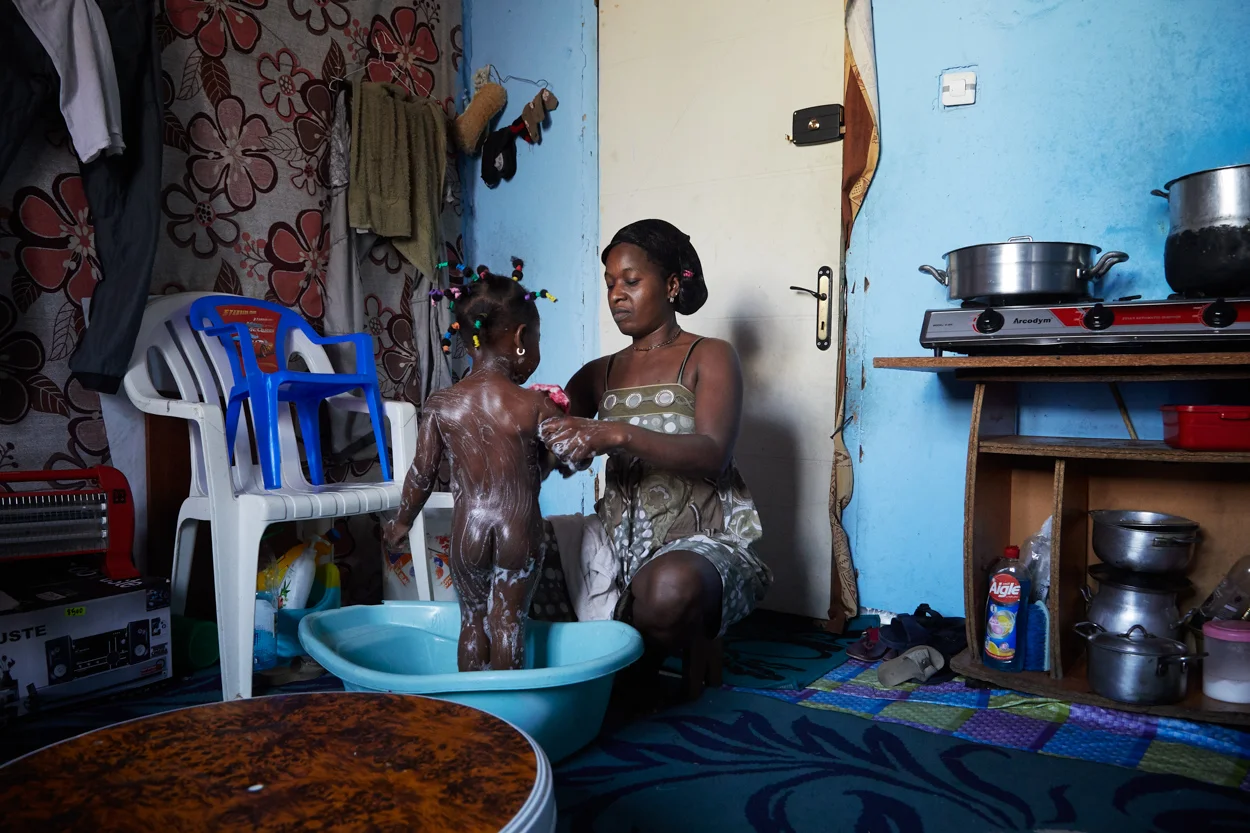  Michelle, 33 ans, est sans travail, sans lien avec le monde extérieur. Elle déprime dans la petite pièce avec sa fille Mira où elle passe la plupart de ses journées à attendre le retour du travail de Bob, son mari. Juillet 2016. Aïn Benian.   