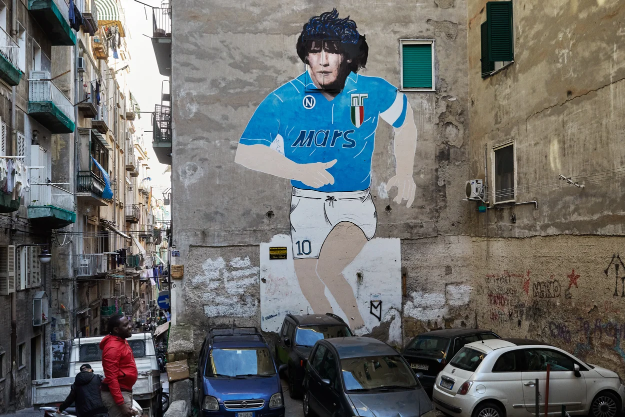  Pascal, ancien résident de Derwisha vit à Naples depuis septembre 2016. Il visite le quartier de Spagnoli connu pour ce portrait de Diego Maradona. Trop occupé à chercher un emploi déclaré pour assurer les besoins de sa famille et renouveler son tit
