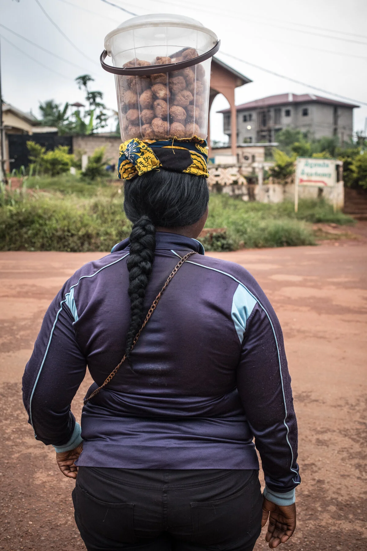  Les « jongleurs » sont ceux qui multiplient les petits jobs. Ici, une vendeuse de gâteaux à 50 Francs CFA l’unité (0,077 centimes d’euros). Yaoundé. Novembre 2019.  