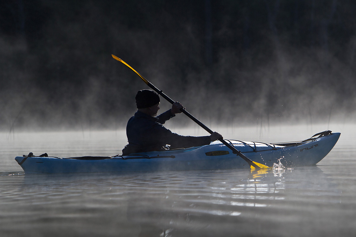 Scott Heister kayaking through the morning mist on Bruin Lake at the Pinckney Recreation Area, Michigan.