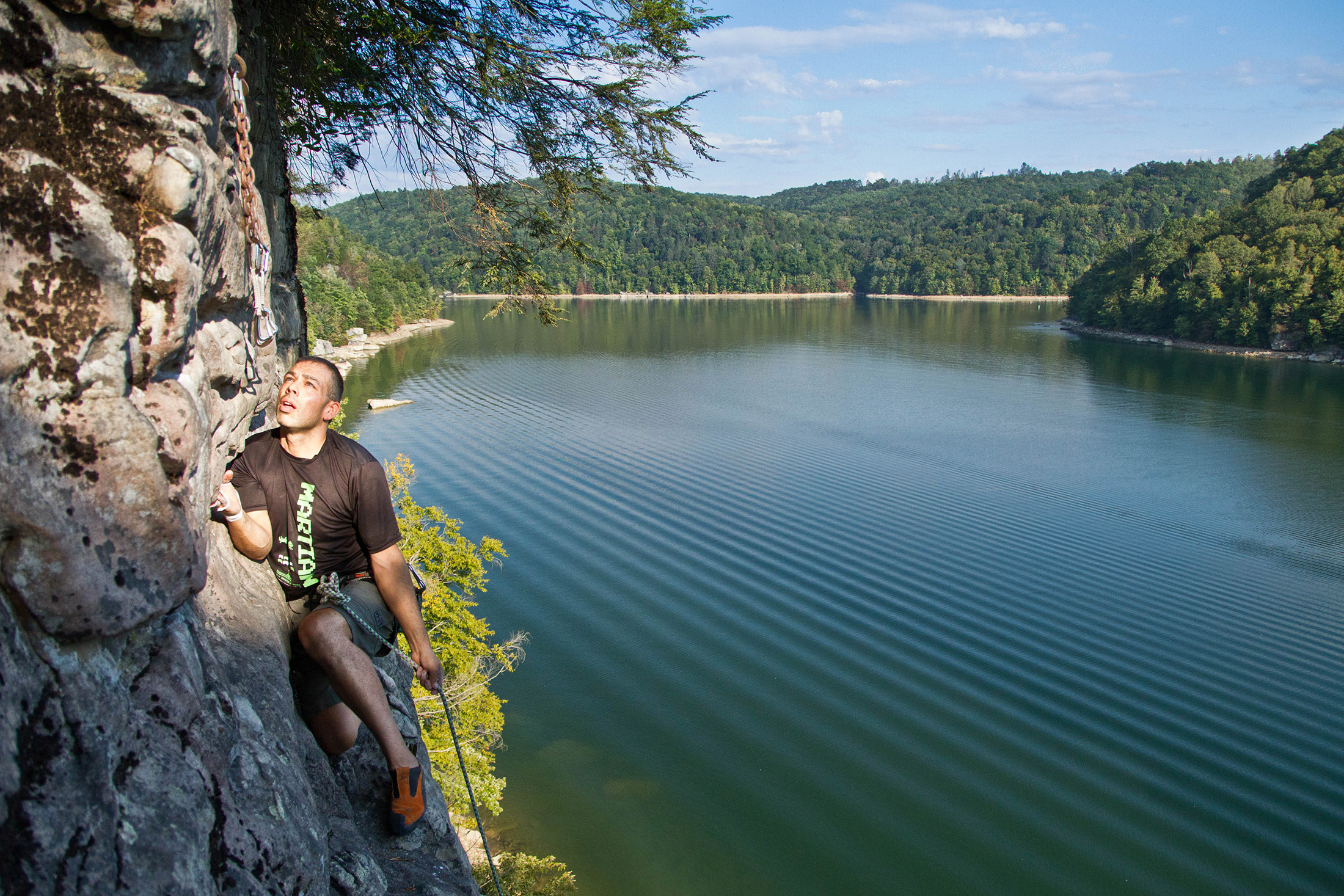 Triathlete Lloyd Brombach completing a rock climb in West Virginia's New River Gorge.