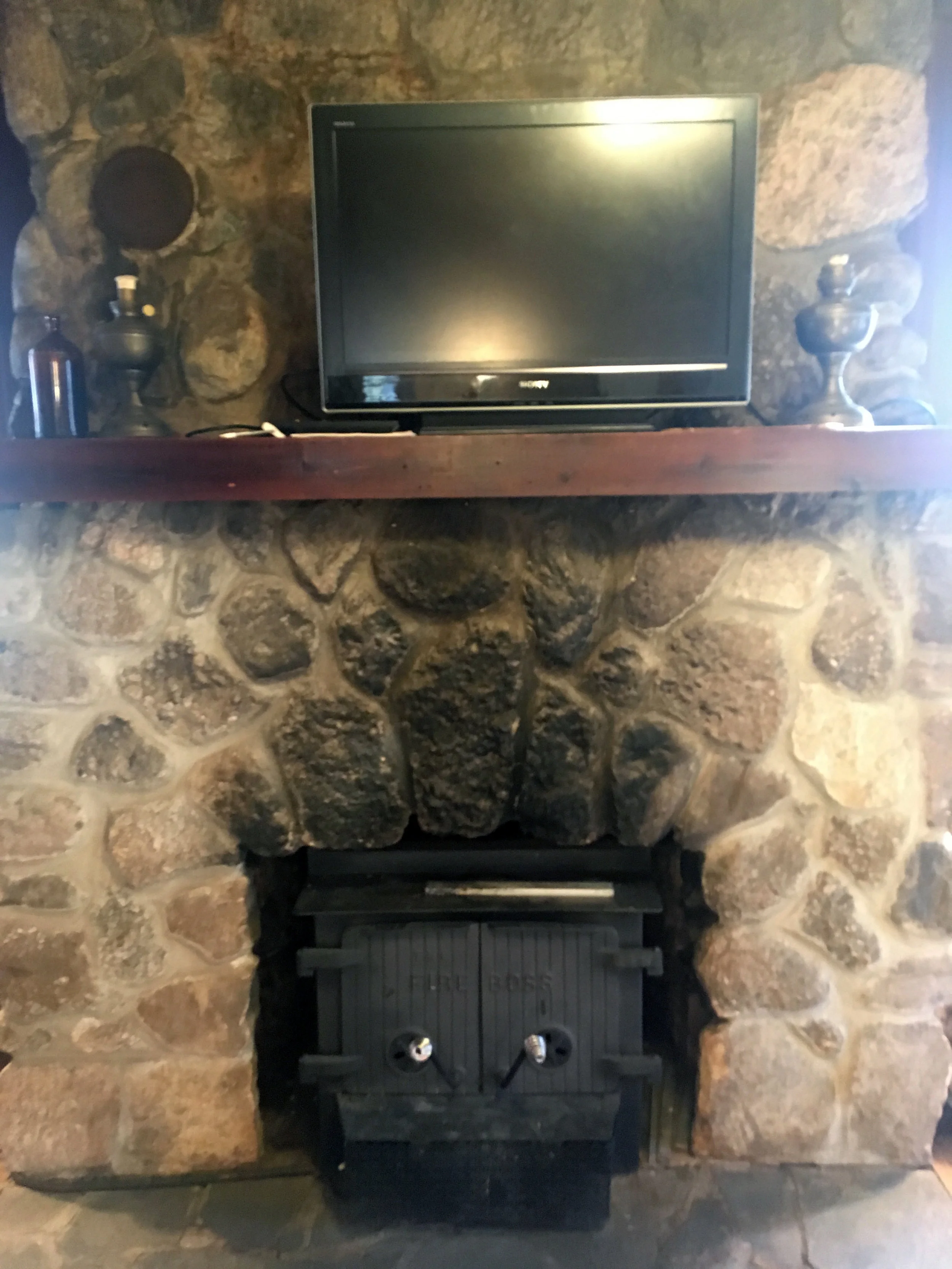 Fireplace has a working wood stove. Flat screen TV has an HDMI cable that can be plugged into computers for streaming.